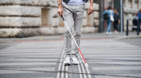 Mann mit Blindenstock auf der Straße